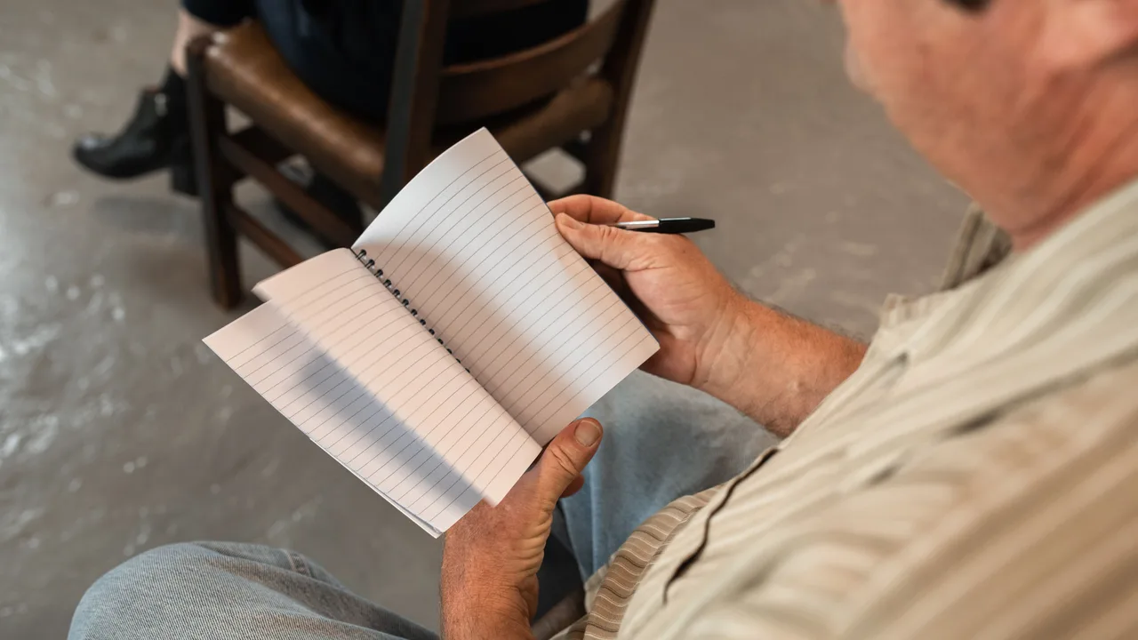 Älterer Mann liest und macht sich Notizen