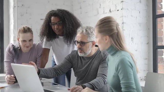 Team arbeitet gemeinsam an einem Laptop