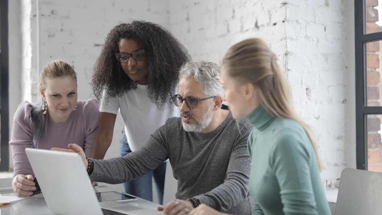 Team arbeitet gemeinsam an einem Laptop