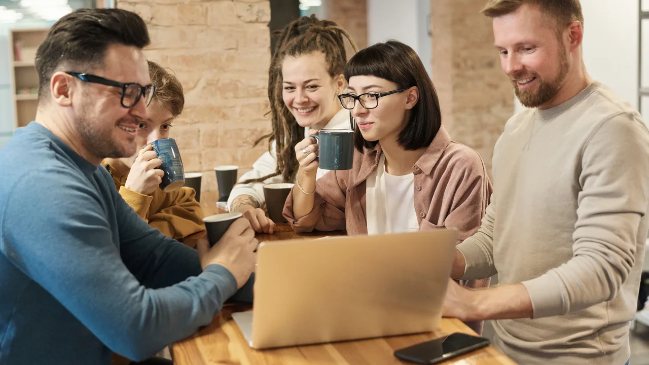 Team im Gespräch bei Kaffee am Laptop