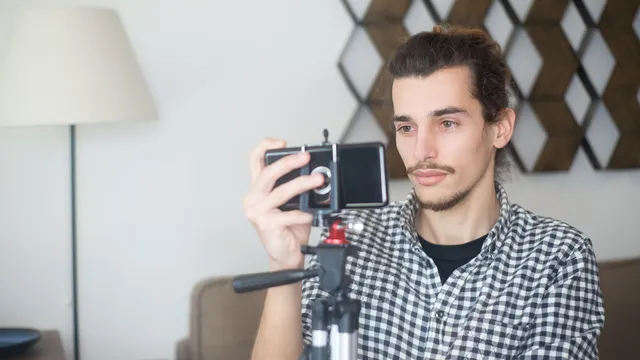 Mann filmt sich mit dem Smartphone auf einem Stativ