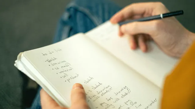 Hand schreibt Notizen in ein Notizbuch
